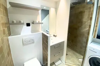 a bathroom with a sink and a washing machine at Cosy 2 pièces - Palais Croisette Cannes in Cannes