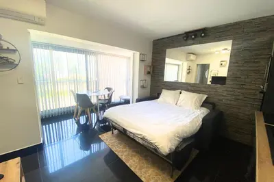 a bedroom with a bed and a table and a mirror at Cosy 2 pièces - Palais Croisette Cannes in Cannes