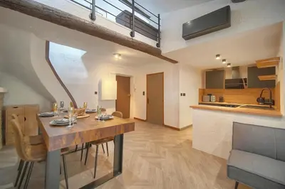 a dining room and kitchen with a wooden table and chairs at Immogroom - T3 - Suquet - AC in Cannes