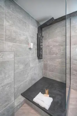 a shower stall with a bench in a bathroom at Immogroom - T3 - Suquet - AC in Cannes