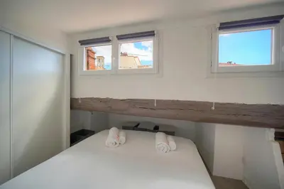 a bedroom with two windows and a white bed at Immogroom - T3 - Suquet - AC in Cannes