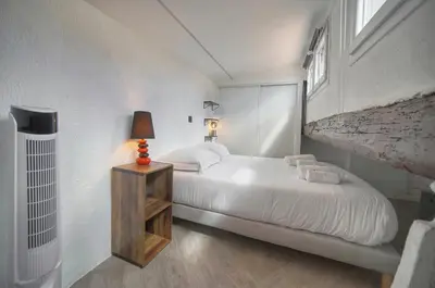 a white bedroom with a bed and a lamp at Immogroom - T3 - Suquet - AC in Cannes