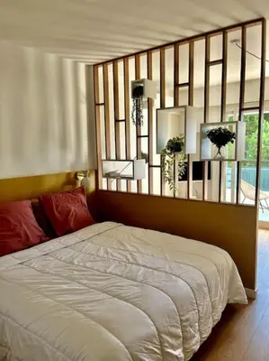 a bedroom with a bed with a mirror above it at Studio calme avec vue sur un grand Pin parasol in Cannes