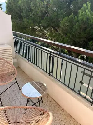 a balcony with two chairs and tables on a balcony at Studio calme avec vue sur un grand Pin parasol in Cannes
