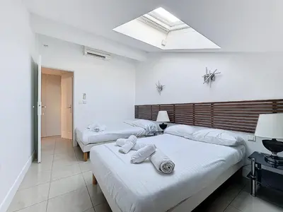 a bedroom with two beds and a skylight at INTUITION - Cannes centre - 6-8 Couchages in Cannes