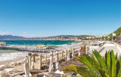 a beach with chairs and umbrellas and the ocean at Nice Apartment In Cannes With Wifi in Cannes
