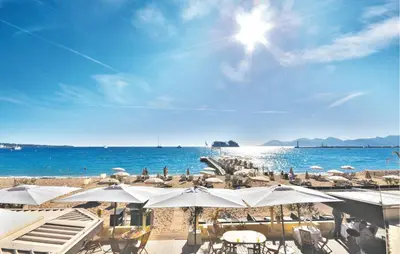 a beach with umbrellas and chairs and the ocean at Nice Apartment In Cannes With Wifi in Cannes