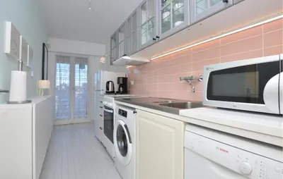a kitchen with a washing machine and a microwave at Nice Apartment In Cannes With Wifi in Cannes