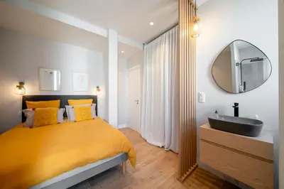a bedroom with a bed with a sink and a mirror at REF 1943 - Cannes Centre - Apartment for rent in Cannes