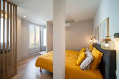 a bedroom with a bed with yellow pillows at REF 1943 - Cannes Centre - Apartment for rent in Cannes