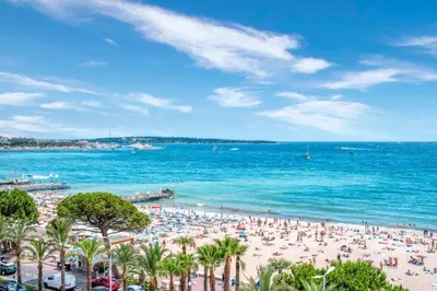 a beach with a lot of people and the ocean at REF 1943 - Cannes Centre - Apartment for rent in Cannes