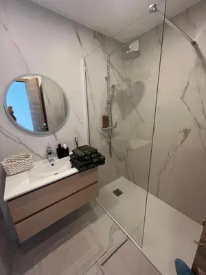a bathroom with a shower and a sink and a mirror at Central Park Cannes in Cannes
