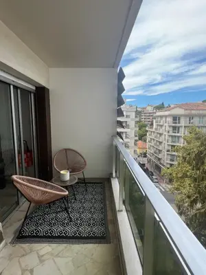 a balcony with a chair and a table on a balcony at Central Park Cannes in Cannes