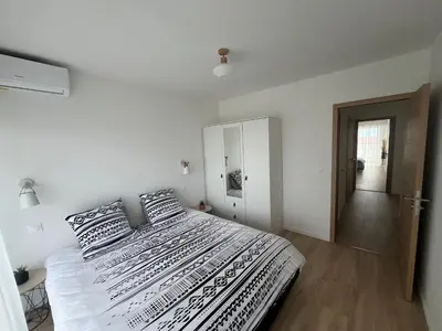 a white bedroom with a large bed with two pillows at Central Park Cannes in Cannes
