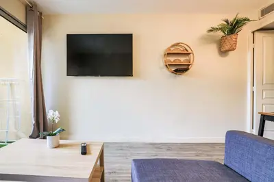 a living room with a flat screen tv on a wall at Le Cannes Beach 408 - cosy Balcon Piscine Netflix in Cannes