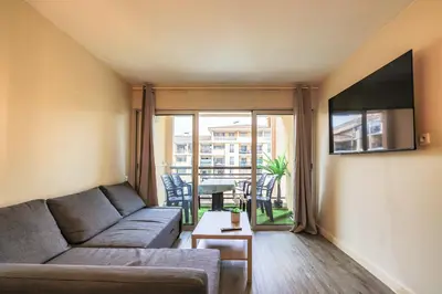 a living room with a couch and a table at Le Cannes Beach 408 - cosy Balcon Piscine Netflix in Cannes