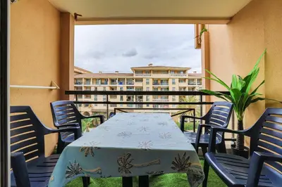 a table and chairs on a balcony with a building at Le Cannes Beach 408 - cosy Balcon Piscine Netflix in Cannes