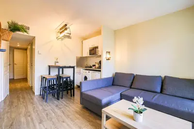 a living room with a couch and a table at Le Cannes Beach 408 - cosy Balcon Piscine Netflix in Cannes