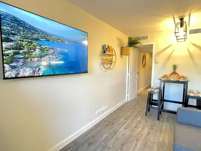 a living room with a large flat screen tv on a wall at Le Cannes Beach 408 - cosy Balcon Piscine Netflix in Cannes