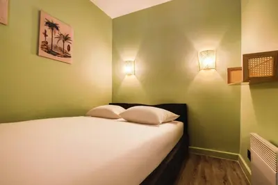 a bedroom with a bed with two pillows on it at Le Cannes Beach 408 - cosy Balcon Piscine Netflix in Cannes