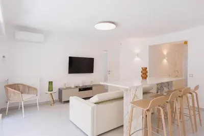 a white living room with a table and chairs at 7 Pradignac Full 3bdrs by Halldis in Cannes