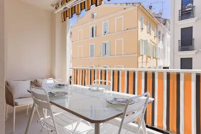 a dining room with a table and chairs on a balcony at 7 Pradignac Full 3bdrs by Halldis in Cannes