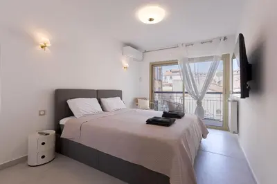 a bedroom with a large bed and a window at 7 Pradignac Full 3bdrs by Halldis in Cannes
