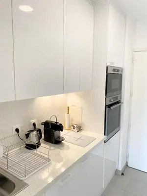 a white kitchen with white cabinets and a sink at Proche Palais Des Festivals - Croisette,Studio Bella - Palmazur Vacances in Cannes