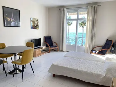 a bedroom with a bed and a table and chairs at 204 - Cannes La Croisette - Studio face mer avec balcon in Cannes