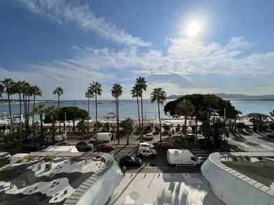 a view of a parking lot with palm trees and the ocean at 204 - Cannes La Croisette - Studio face mer avec balcon in Cannes