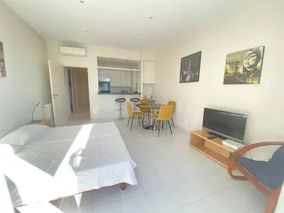 a room with a bed and a television and a table at 204 - Cannes La Croisette - Studio face mer avec balcon in Cannes