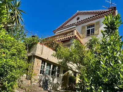 an old house with a tile roof and trees at Villa Tricia Cannes in Cannes
