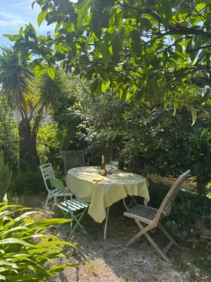 a table and two chairs sitting under a tree at Villa Tricia Cannes in Cannes