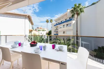 a white table and chairs on a balcony with a view of a building at 3-Br Apartment with Pool Parking & Beaches 100m away in Cannes