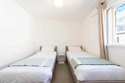 two beds in a small room with a window at 3-Br Apartment with Pool Parking & Beaches 100m away in Cannes