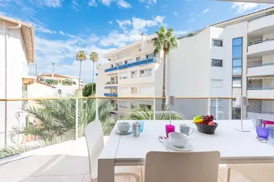 a white table and chairs on a balcony with a view of a building at 3-Br Apartment with Pool Parking & Beaches 100m away in Cannes