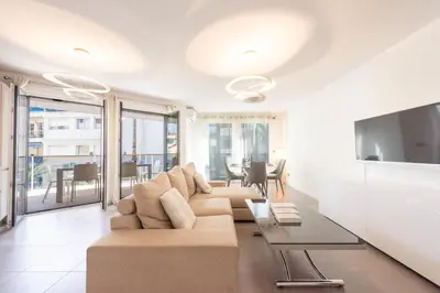 a living room with a couch and a tv at 3-Br Apartment with Pool Parking & Beaches 100m away in Cannes