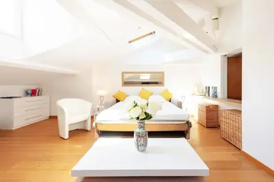 a bedroom with a bed and a table with a vase of flowers at Luxurious StudioLoft 3 MINUTES FROM LA CROISETTE in Cannes