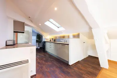 an attic kitchen with white cabinets and a skylight at Luxurious StudioLoft 3 MINUTES FROM LA CROISETTE in Cannes