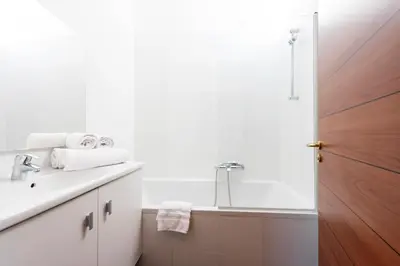a white bathroom with a sink and a shower at Luxurious StudioLoft 3 MINUTES FROM LA CROISETTE in Cannes
