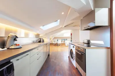 a kitchen with white cabinets and a washer and dryer at Luxurious StudioLoft 3 MINUTES FROM LA CROISETTE in Cannes