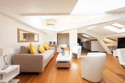 a living room with a couch and a table at Luxurious StudioLoft 3 MINUTES FROM LA CROISETTE in Cannes