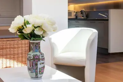 a vase filled with white flowers next to a white chair at Luxurious StudioLoft 3 MINUTES FROM LA CROISETTE in Cannes