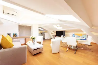 a living room with a couch and a table at Luxurious StudioLoft 3 MINUTES FROM LA CROISETTE in Cannes