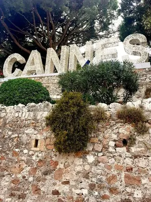 a sign for a zoo with plants on a stone wall at le cosy de carole in Cannes