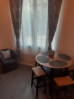 a room with a table and a chair and a window at le cosy de carole in Cannes