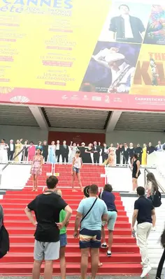 a group of people walking down a red stairs at le cosy de carole in Cannes