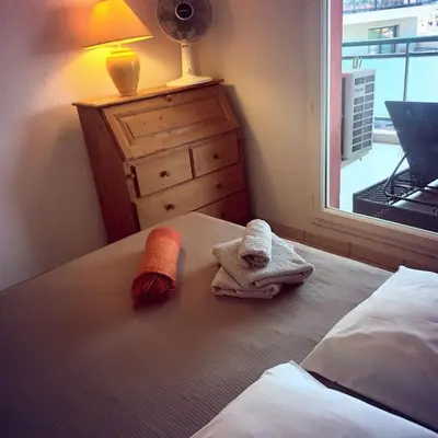 a bedroom with two towels on a bed with a window at Apt calme 2 chambres vue dégagée in Cannes