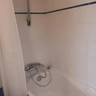 a shower in a white tiled bathroom at Apt calme 2 chambres vue dégagée in Cannes