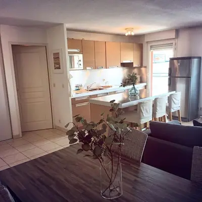 a kitchen with a table with a vase on it at Apt calme 2 chambres vue dégagée in Cannes